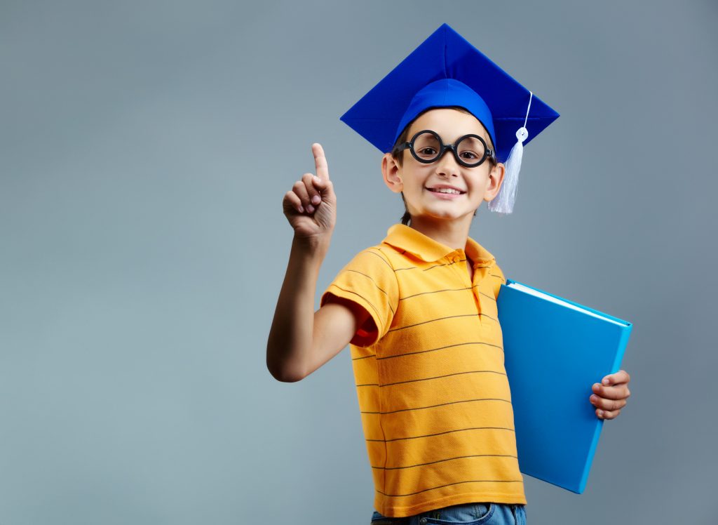 proud little boy with glasses and graduation cap